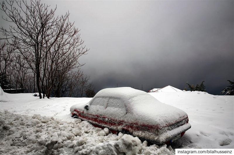 A car is covered with snow during a heavy snowfall in the village of...