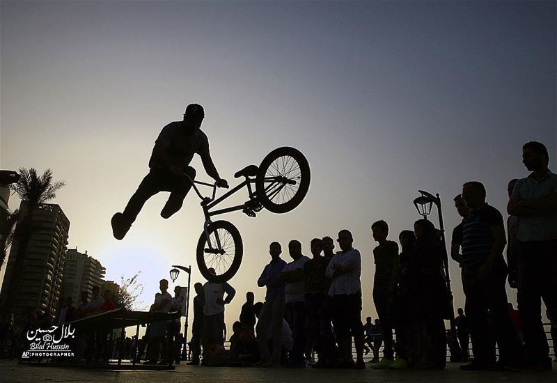 A crowd watches Walid Kasim, 23, a Turkish cyclist living in Lebanon, as...