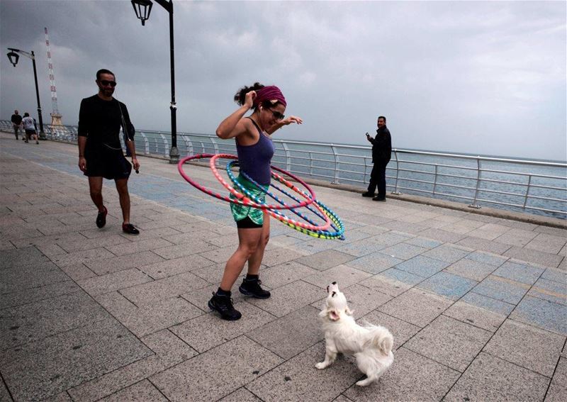 A woman spins hula hoops near a dog at Beirut’s Corniche, Lebanon. (Jamal Saidi / REUTERS) via pow.photos