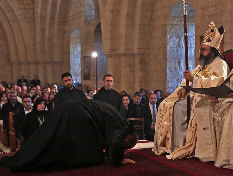 Christian monk kneels in front of his Bishop during an ordination ceremony held at the monastery of Saint Anthony in Ghazir north of Beirut. (PATRICK BAZ / AFP)