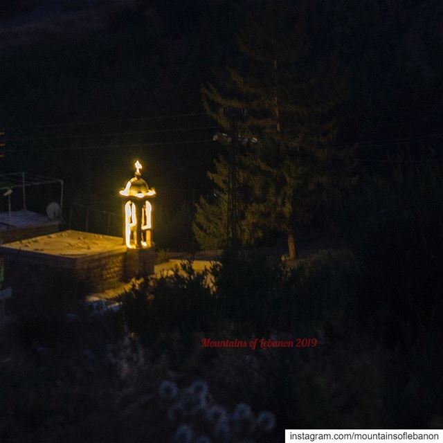 in the dark night, an illuminated small church bell tower, next to a fir... (Afka, Mont-Liban, Lebanon)