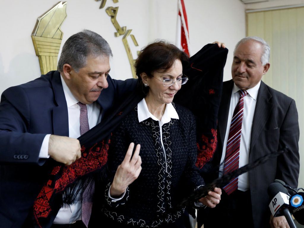 Palestinian Ambassador Ashraf Dabbour (L) helps ESCWA Executive Secretary Rima Khalaf (C) put on a traditional Palestinian scarf after announcing her resignation from her position, in Beirut. (Jamal Saidi / REUTERS) via pow.photos 