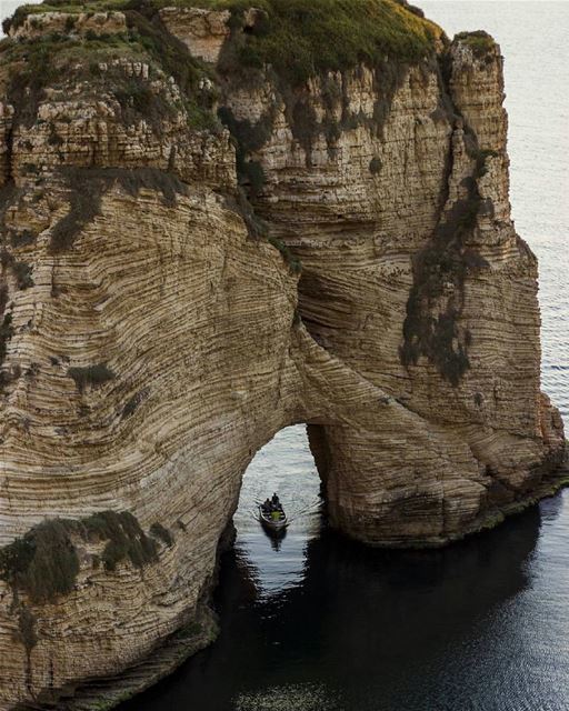 A boat going under the raouche rock ⚓By @ralphhatoum  Rawché  Rawshe ... (Rouche)