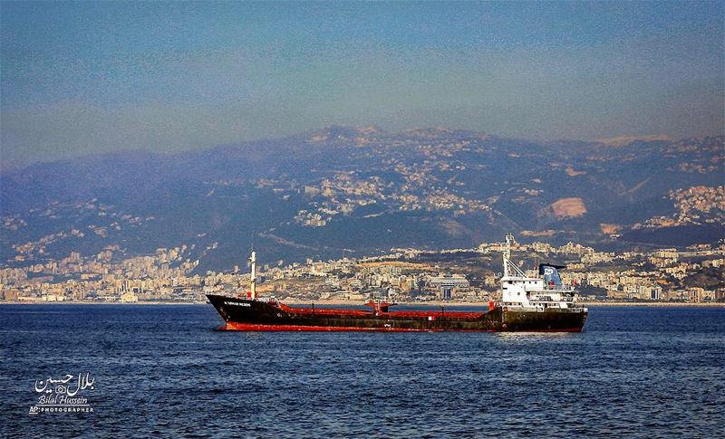A cargo ship navigates in the Mediterranean Sea along the Beirut coastline,