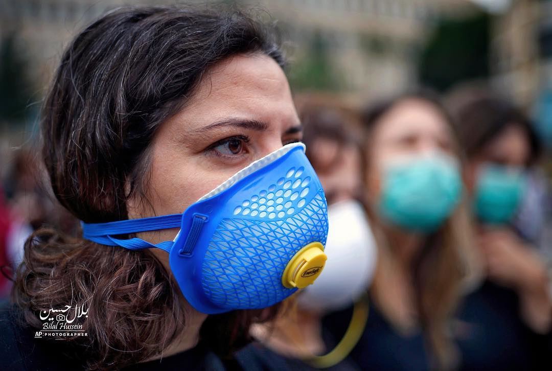 A Lebanese anti-government protester wears a surgical mask during a...