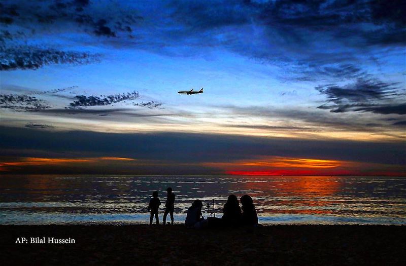 A Lebanese family sits as they smoke a water pipe on the beach at the...