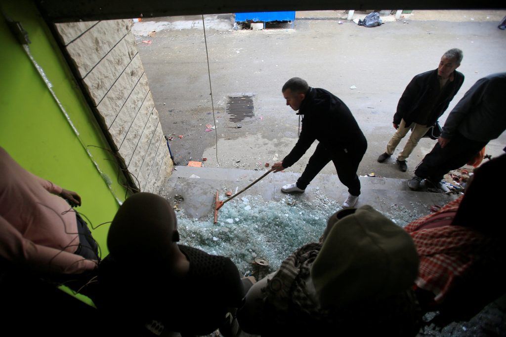 A man cleans a damaged shop in the Ain el-Hilweh Palestinian refugee camp. (Ali Hashisho / REUTERS) via pow.photos