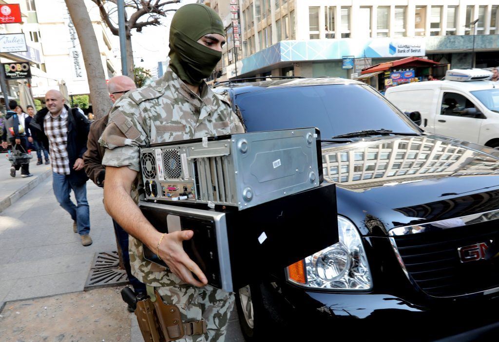 A member of Security Forces confiscated computers as they carry out raids at suspected banking institutions in Hamra. (ANWAR AMRO / AFP) via pow.photos