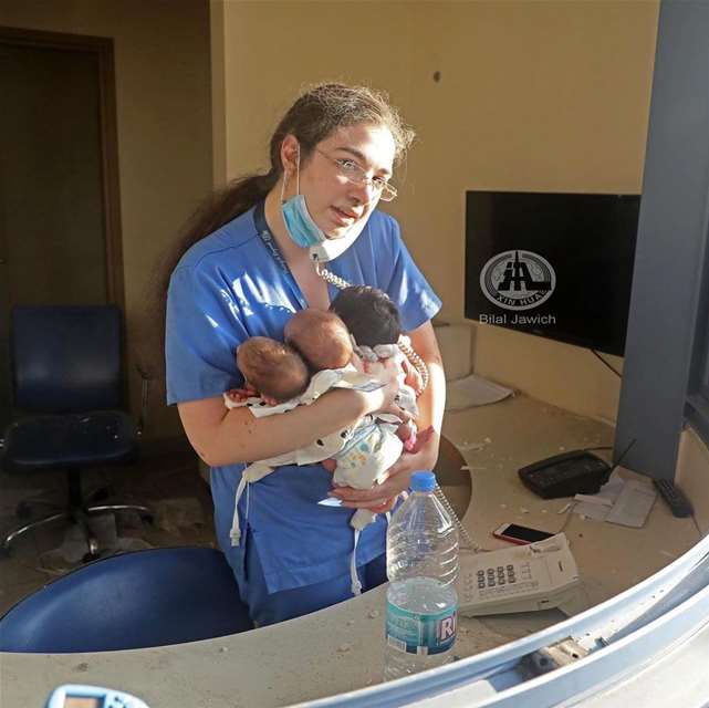 A nurse holding 3 babies after the St. Georges Roum hospital was almost destroyed due to the blast that happened in Beirut in August 4, 2020