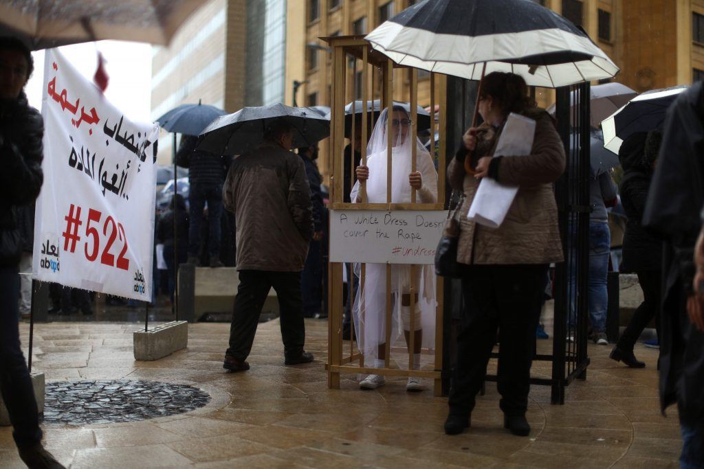 A protester depicting a bride in a cage, during a protest, as MP vote against article 522 that shields rapists from prosecution. (PATRICK BAZ / AFP) via pow.photos 