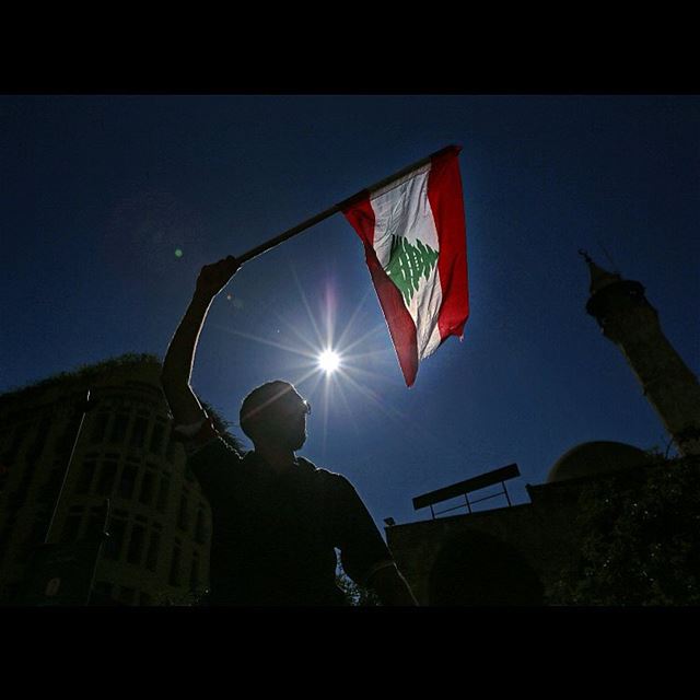A right-wing Christian Phalange Party supporter waves a Lebanese flag...
