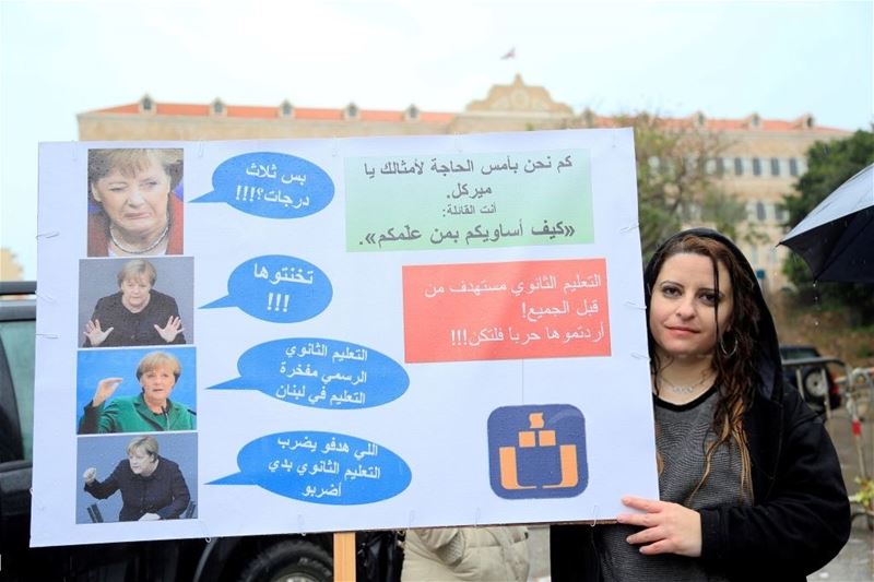 A teacher holds a placard during a demonstration demanding a wage increase at Riad Al Solh Square. (Ratib Al Safadi / Anadolu Agency) via pow.photos 