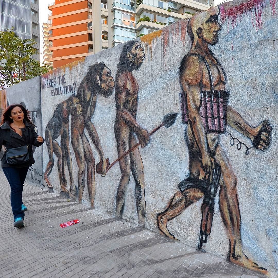 A woman walks next to a mural on a street in Beirut, Lebanon