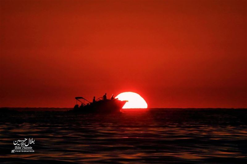 A yacht sails as the sun sets over the Mediterranean Sea along the Beirut...