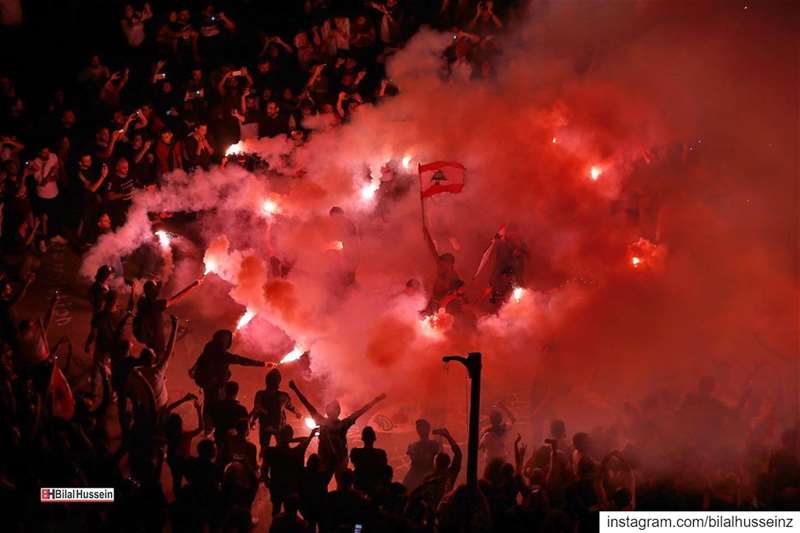 Anti-government protesters light flares and chant slogans against the...