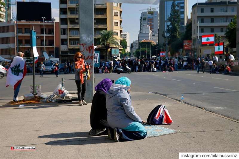 Anti-government protesters pray, as others block a main highway in Beirut,...