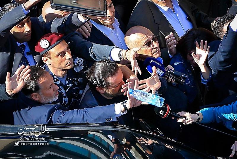 Bodyguards protect Lebanese Prime Minister Saad Hariri, center, from a...