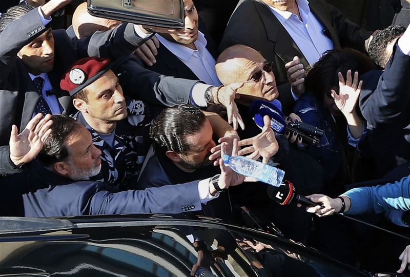 Bodyguards protect Saad Hariri, from a water bottle thrown by demonstrators in downtown Beirut. (Bilal Hussein / AP) via pow.photos
