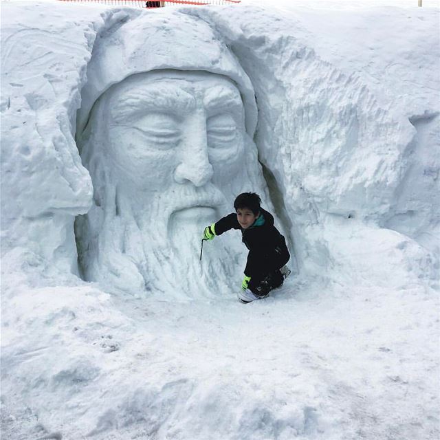 Criança brinca ao lado de São Charbel esculpido no gelo por um artista... (Zaarour Club)