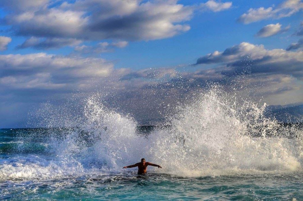 Despite the cold weather, a man is hit by waves during an early morning swim in Beirut. (Hassan Ammar)