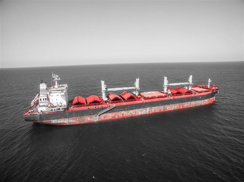 Drone shot of a ship docked in front of Colonel beer shores in Batroun ...