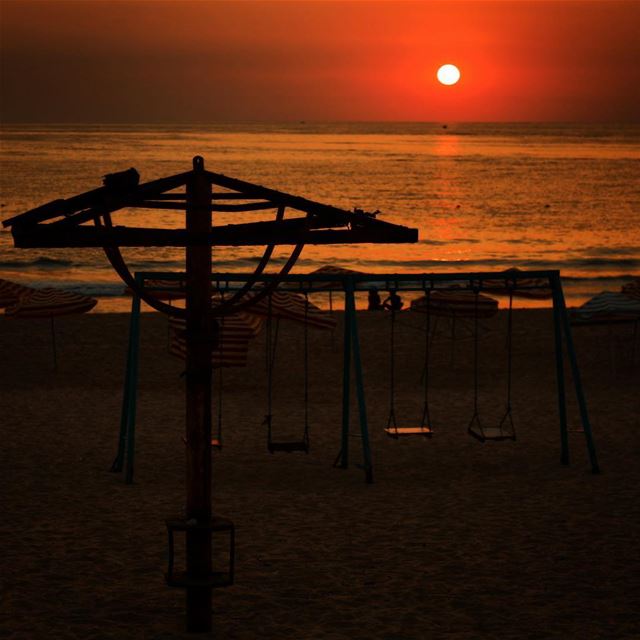 Empty swings, deserted beach and a broken umbrella killed by the wind ,...