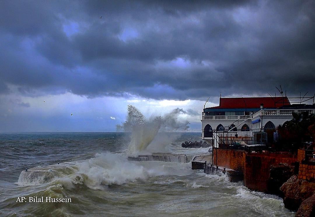 Huge waves crash on the sea defense wall of a restaurant, at the Beirut...