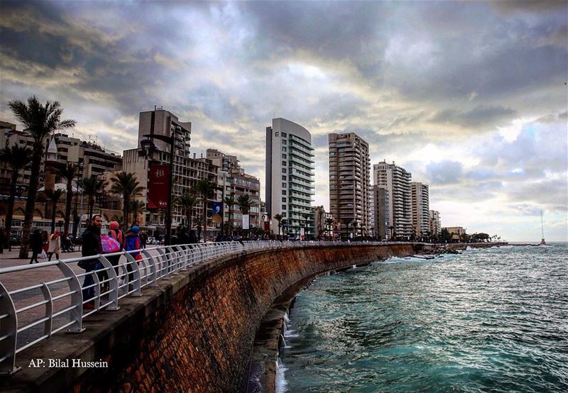 Lebanese citizens stand on the seafront, along the Mediterranean Sea, as...