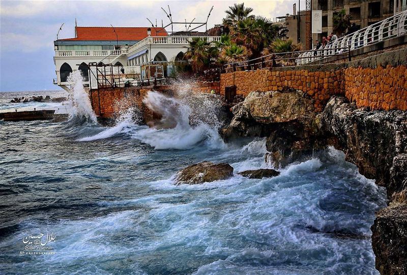 Lebanese stand on the Corniche as they look to high waves crash on the...