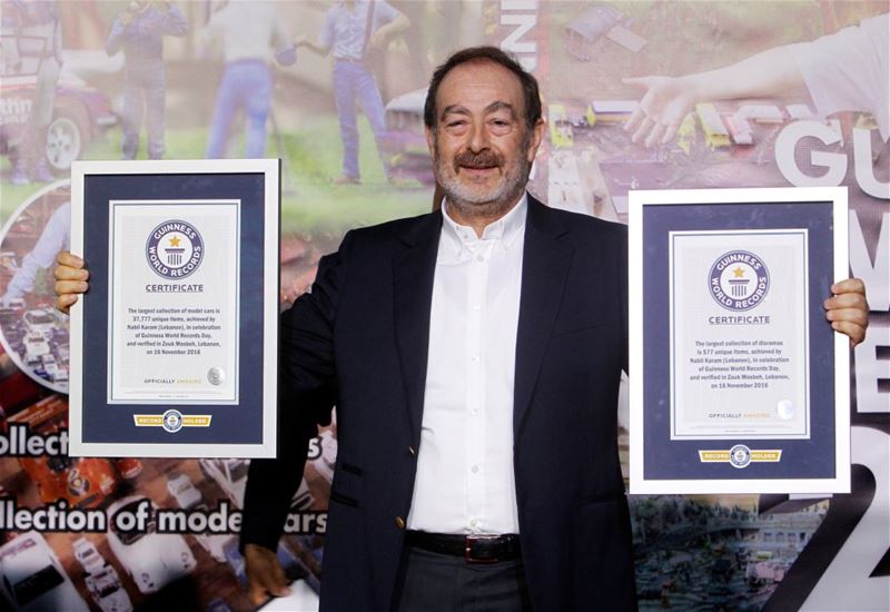 Nabil Karam poses with his Guinness World Record certificates for the largest collection of model cars and the largest collection of dioramas, in Zouk Mosbeh.