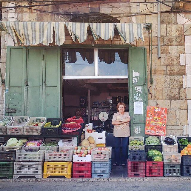 Owner of a grocery shop in Hasroun contemplates traffic while waiting for customers to come in (Hasroun)