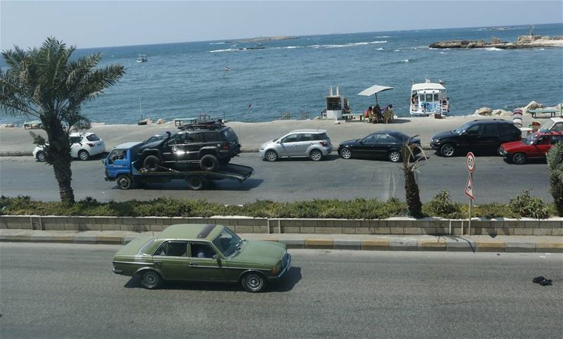 Passing by younger car being carried, while driving an old one along the... (Tripoli, Lebanon)