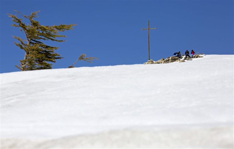 People pray next to a cross on the top of a mountain at the Faraya-Mzaar ski resort. (Hassan Ammar / AP) via pow.photos