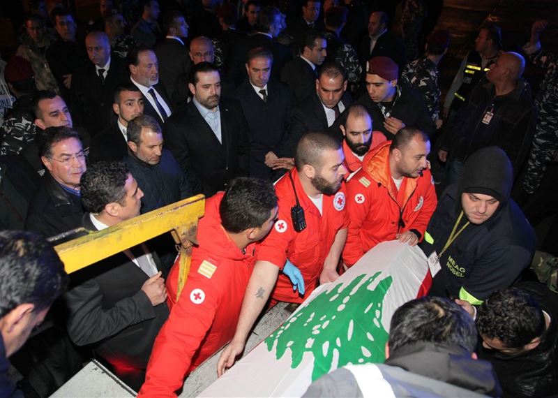Saad Hariri looking at coffins of three Lebanese who were killed in the Reina shooting as they are being repatriated at Beirut airport.