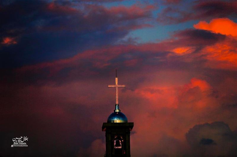 Saint George Maronite Cathedral’s cross is lit while heavy clouds darken...