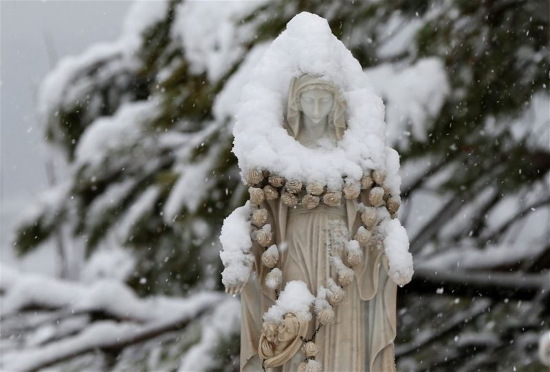 Snow covering a statue of the Virgin Mary in Bikfaya