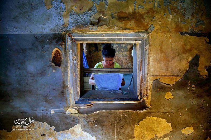 visitor weaves woolen patches on a loom to cover bullet holes on the...